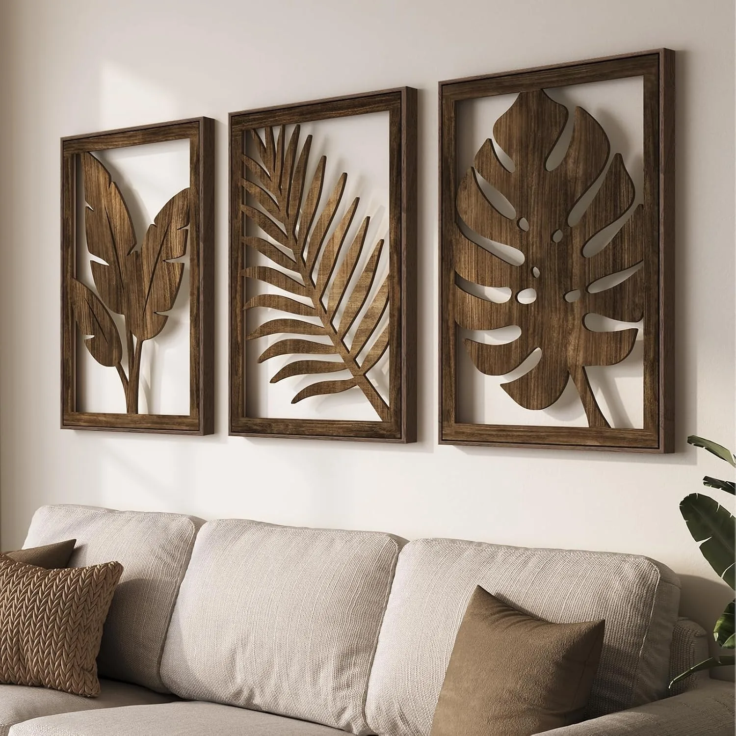 Three carved botanical wood wall art panels above a neutral linen bed, warm natural light, and soft boho bedroom decor