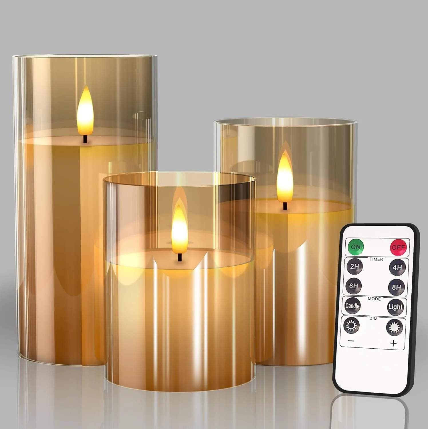 Three gold glass flameless pillar candles with warm flickering LED flames and a remote, styled as elegant neutral home lighting
